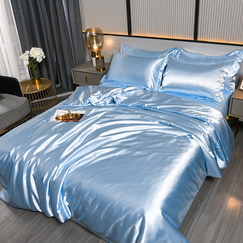 Blue satin bedding set on a bed in a bedroom setting.