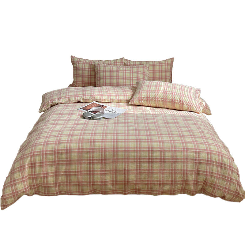 Plaid bedding set with pillows and a magazine on a white background