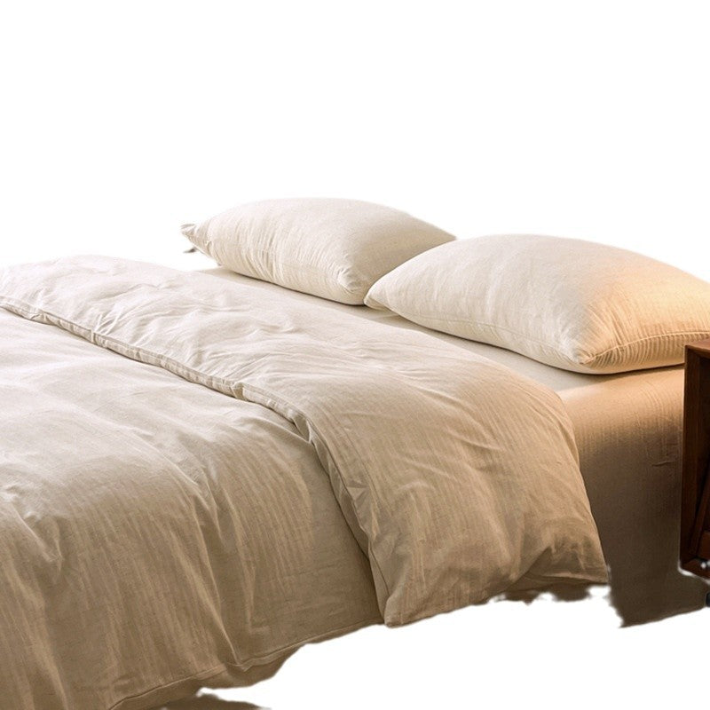 Beige comforter and pillows on a bed with a white background