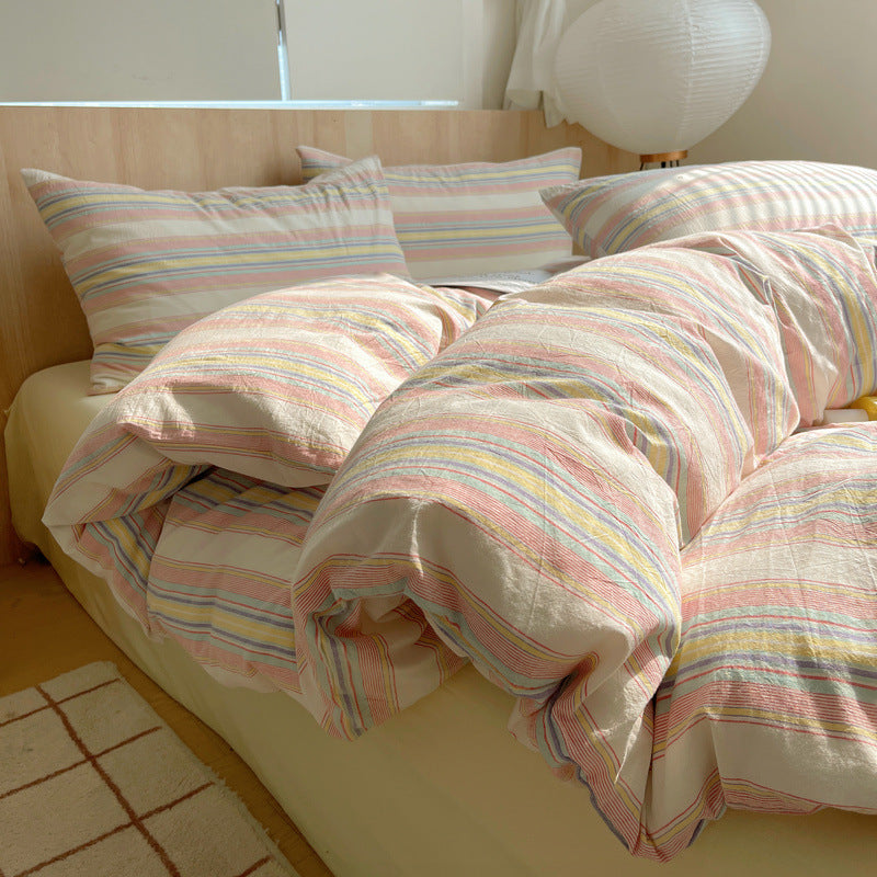 Bed with striped bedding and pillows in a bright room